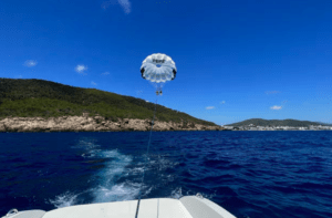 Experimente el emocionante Vuelo en Parasailing en Santa Eulalia del Río, elevándose sobre aguas azules mientras un barco lo remolca a lo largo de la impresionante costa montañosa. - ForTwo - Planes para parejas