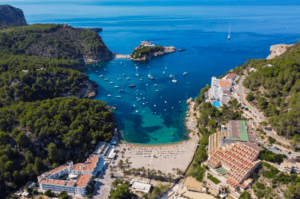 Vea la bahía costera de Ibiza al amanecer con barcos, playas de arena, colinas exuberantes y edificios desde Vuelo en globo: Ibiza desde las alturas al amanecer. - ForTwo - Planes para parejas