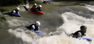 Un grupo con cascos disfruta de la emoción del Hidrospeed en el Alto Ebro, surcando rápidos con bodyboards a través de aguas rápidas. - ForTwo - Planes para parejas