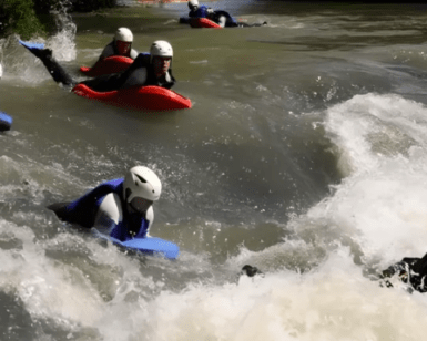 Un grupo con cascos disfruta de la emoción del Hidrospeed en el Alto Ebro, surcando rápidos con bodyboards a través de aguas rápidas. - ForTwo - Planes para parejas