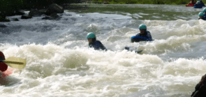 En un día soleado, los aventureros con casco navegan por los rápidos del Alto Ebro en kayaks, mientras otros eligen la emoción del Hidrospeed en el Alto Ebro. - ForTwo - Planes para parejas