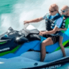 Dos personas surcan las aguas turquesas de Menorca en una "Alquila una Moto de Agua en Menorca", equipadas de forma segura con chalecos salvavidas y gafas de sol. - ForTwo - Planes para parejas