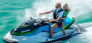 Dos personas surcan las aguas turquesas de Menorca en una "Alquila una Moto de Agua en Menorca", equipadas de forma segura con chalecos salvavidas y gafas de sol. - ForTwo - Planes para parejas