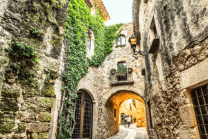 Explora el encanto de Girona a través de su producto, "Descubre Pueblos Medievales desde Girona", donde estrechos callejones adoquinados, muros de piedra cubiertos de hiedra y cálidas farolas iluminan atractivos pueblos medievales. - ForTwo - Planes para parejas
