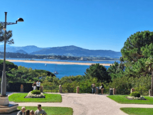 Explora un parque con impresionantes vistas de la Bahía de Santander, donde los veleros se deslizan contra impresionantes montañas y un cielo azul, cerca del histórico Palacio de la Magdalena con "Descubre el Palacio de la Magdalena". - ForTwo - Planes para parejas