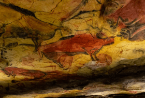 En "Descubre la Neocueva de Altamira" destacan antiguas pinturas rupestres de bisontes en rojo y negro, con sus formas magistralmente grabadas en la superficie texturizada adornada con grietas históricas. - ForTwo - Planes para parejas