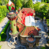 Una vista aérea del vibrante Capricho de Gaudí, que recuerda el estilo caprichoso de Gaudí, revela sus coloridos azulejos rodeados de exuberante vegetación. - ForTwo - Planes para parejas