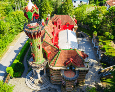 Una vista aérea del vibrante Capricho de Gaudí, que recuerda el estilo caprichoso de Gaudí, revela sus coloridos azulejos rodeados de exuberante vegetación. - ForTwo - Planes para parejas