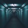 El túnel angosto y poco iluminado de Mérida, con paredes corrugadas y luces fluorescentes en el techo, recuerda a una escena de Escape Room en Mérida, mientras se aleja siniestramente hacia la oscuridad. - ForTwo - Planes para parejas