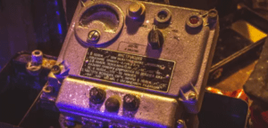 En la Sala de Escape de Mérida, un panel de control vintage iluminado con botones e interruptores invita a los participantes. La tenue iluminación crea sombras sobre las instrucciones en ruso, realzando el encanto misterioso de la experiencia. - ForTwo - Planes para parejas
