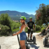 Un grupo de aventureros ataviados con cascos se desliza en Segways por un sendero rocoso, inmersos en los impresionantes paisajes gracias a "Explora la Sierra de Castril en Segway". - ForTwo - Planes para parejas