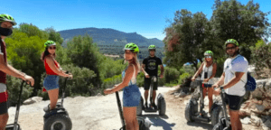 Un grupo de aventureros ataviados con cascos se desliza en Segways por un sendero rocoso, inmersos en los impresionantes paisajes gracias a "Explora la Sierra de Castril en Segway". - ForTwo - Planes para parejas