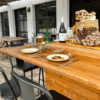 Un patio al aire libre cuenta con una mesa de madera para dos, con bebidas, platos de comida y una canasta de las mejores Finca de Setas en Menorca de Menorca como decoración. - ForTwo - Planes para parejas