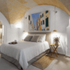La acogedora habitación del Hotel Nou Sant Antoni: En el Corazón de Ciutadella cuenta con un techo abovedado, decoración neutra, arte mural y una iluminación tenue que da acceso al baño. Ideal para su estancia en el corazón de Ciutadella. - ForTwo - Planes para parejas