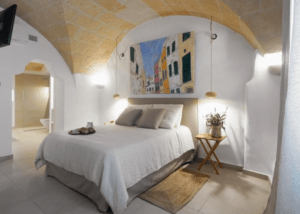 La acogedora habitación del Hotel Nou Sant Antoni: En el Corazón de Ciutadella cuenta con un techo abovedado, decoración neutra, arte mural y una iluminación tenue que da acceso al baño. Ideal para su estancia en el corazón de Ciutadella. - ForTwo - Planes para parejas