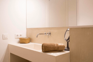 En el Hotel Nou Sant Antoni: En el Corazón de Ciutadella te espera un moderno baño con lavabo rectangular, toalla enrollada, cesta de mimbre y grifo de pared, diseñado para que te sientas como en casa en el corazón de Menorca. - ForTwo - Planes para parejas