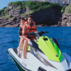 Dos amantes de las emociones fuertes con chalecos salvavidas disfrutan de un paseo en moto acuática por la Costa de Cantabria, deslizándose por aguas azules cristalinas cerca de impresionantes acantilados rocosos. - ForTwo - Planes para parejas