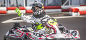 En Estepona, alguien con casco y mono de carreras hace un gesto de aprobación con el pulgar mientras disfruta del Karting en Estepona en la pista. - ForTwo - Planes para parejas