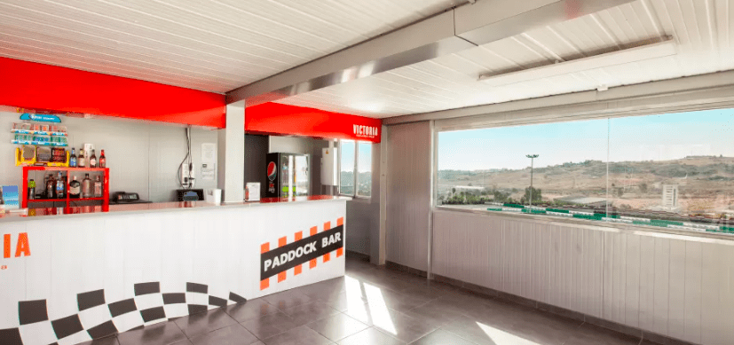 Área vibrante temática de Karting en Estepona, completa con un mostrador, taburetes de bar y una gran ventana que ofrece impresionantes vistas al campo en Estepona. - ForTwo - Planes para parejas