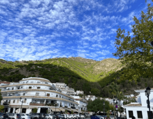 Disfrute de una vista panorámica de Mijas con "Marbella y Mijas: disfruta la Costa del Sol", que muestra una encantadora ciudad en la ladera con icónicos edificios blancos en medio de exuberantes colinas verdes bajo un cielo azul nublado. - ForTwo - Planes para parejas