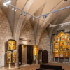 El Museo de Arte de Girona cuenta con una pinacoteca con techos abovedados de piedra, donde se exponen pinturas religiosas y retablos iluminados con focos. - ForTwo - Planes para parejas