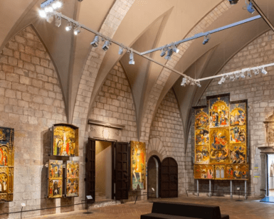 El Museo de Arte de Girona cuenta con una pinacoteca con techos abovedados de piedra, donde se exponen pinturas religiosas y retablos iluminados con focos. - ForTwo - Planes para parejas