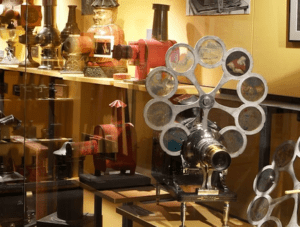 Los proyectores de películas antiguas se exhiben de forma cautivadora en las estanterías del Museu del Cinema de Girona, resaltando diversos diseños y detalles coloridos. - ForTwo - Planes para parejas