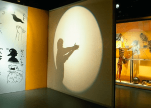 Creando intrincadas sombras con las manos bajo un foco en el animado Museu del Cinema de Girona, rodeado de cautivadoras exhibiciones que animan la historia del cine. - ForTwo - Planes para parejas