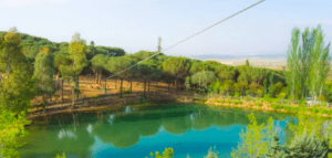 En Hornachos, el Parque de Aventura cuenta con un lago sereno entre frondosos árboles, una emocionante tirolesa en lo alto y colinas onduladas en la distancia, que prometen una experiencia inolvidable. - ForTwo - Planes para parejas