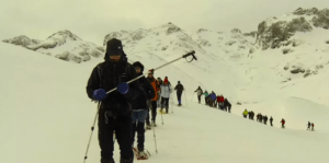 Un grupo explora la impresionante belleza de los Picos de Europa cubiertos de nieve, caminando con raquetas de nieve en línea y vestidos con ropa de invierno utilizando Raquetas de Nieve en Picos de Europa. - ForTwo - Planes para parejas