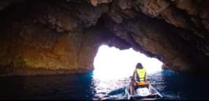 Una persona en una moto de agua navega hacia una cueva rocosa en la Ruta en Moto de Agua por las Islas Medas, descubriendo la luz deslumbrante al otro extremo. - ForTwo - Planes para parejas