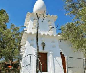 Ubicado en el sereno paisaje de Portlligat, el edificio blanco con una icónica escultura de huevo en su techo, rodeado de frondosos árboles y un cielo despejado, le invita a vivir una experiencia memorable: "Visita la Casa de Dalí en Portlligat". - ForTwo - Planes para parejas
