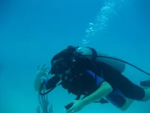 Bajo el agua cerca de Marbella, un buceador da la señal de OK entre burbujas ascendentes en aguas azules cristalinas, disfrutando de una inmersión de buceo en Marbella. - ForTwo - Planes para parejas