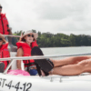Cuatro personas con chalecos salvavidas navegan pacíficamente en una pequeña embarcación a través de un exuberante lago verde, capturando el encanto de Santander y la libertad de un Barco sin licencia en Santander. - ForTwo - Planes para parejas