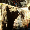Dos aventureros, apasionados del barranquismo en la Sierra de Cardeña y Montoro, hacen rappel con destreza por una cascada rocosa en el frondoso bosque. - ForTwo - Planes para parejas