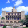 La Catedral de Mallorca y Palacio Real, una fortaleza histórica con arcos, torres y jardines bajo un cielo azul, está elegantemente situada junto al impresionante Palacio Real de Palma de Mallorca. - ForTwo - Planes para parejas