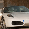 Un elegante convertible blanco "Conduce un Ferrari o Lamborghini en Córdoba" está estacionado en un camino de tierra, enmarcado por la exuberante vegetación de los árboles de Córdoba. - ForTwo - Planes para parejas