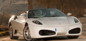 Un elegante convertible blanco "Conduce un Ferrari o Lamborghini en Córdoba" está estacionado en un camino de tierra, enmarcado por la exuberante vegetación de los árboles de Córdoba. - ForTwo - Planes para parejas