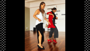 En un estudio de baile de Marbella, dos mujeres practican con pasión: una de blanco y negro, la otra de rojo fuego, recordando al "Curso privado de baile flamenco en Marbella". - ForTwo - Planes para parejas