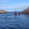 Dos kayakistas navegan entre acantilados rocosos cerca de Girona en una aventura de Escape Room en Kayak, rodeados de un mar que promete emoción bajo el inmenso cielo azul. - ForTwo - Planes para parejas