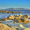Costas rocosas con un mar azul, grandes rocas dispersas y colinas bajas distantes bajo un cielo despejado lo hacen perfecto para una "Excursión en Barco a la Isla de Ons". - ForTwo - Planes para parejas