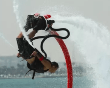 Alguien ejecutando un flip en un Flyboard en Valencia con el hermoso paisaje urbano de Valencia de fondo. - ForTwo - Planes para parejas