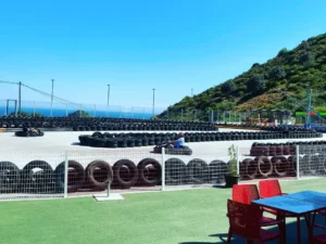 El Karting en Ojén ofrece una emocionante pista de karts al aire libre junto al mar, donde los conductores corren entre neumáticos apilados con asientos en primer plano. - ForTwo - Planes para parejas