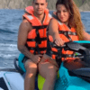 Dos personas con chalecos salvavidas circulan en una Moto de agua en Getxo sin carnet por el océano con los acantilados rocosos de Getxo al fondo. - ForTwo - Planes para parejas