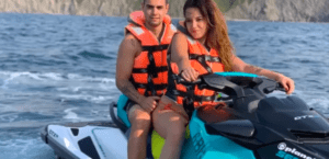 Dos personas con chalecos salvavidas circulan en una Moto de agua en Getxo sin carnet por el océano con los acantilados rocosos de Getxo al fondo. - ForTwo - Planes para parejas