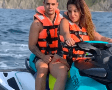 Dos personas con chalecos salvavidas circulan en una Moto de agua en Getxo sin carnet por el océano con los acantilados rocosos de Getxo al fondo. - ForTwo - Planes para parejas