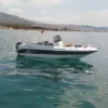El Navega en Pareja por la Costa del Sol, un pequeño barco a motor blanco y azul, flota en las serenas aguas cerca de la hermosa costa de la Costa del Sol, con montañas distantes como un impresionante telón de fondo. - ForTwo - Planes para parejas