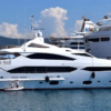 Un Yate de Lujo en Girona está elegantemente atracado cerca de un crucero en el soleado puerto, ofreciendo una Noche Romántica en sus opulentas cubiertas. - ForTwo - Planes para parejas