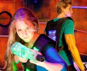 En el vibrante entorno de Alfafar, dos jugadores de laser tag se preparan, apuntando con sus pistolas Oferta: 2 partidas de Laser Tag en Alfafar entre luces de neón, listos para emocionantes partidas. - ForTwo - Planes para parejas