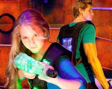 En el vibrante entorno de Alfafar, dos jugadores de laser tag se preparan, apuntando con sus pistolas Oferta: 2 partidas de Laser Tag en Alfafar entre luces de neón, listos para emocionantes partidas. - ForTwo - Planes para parejas